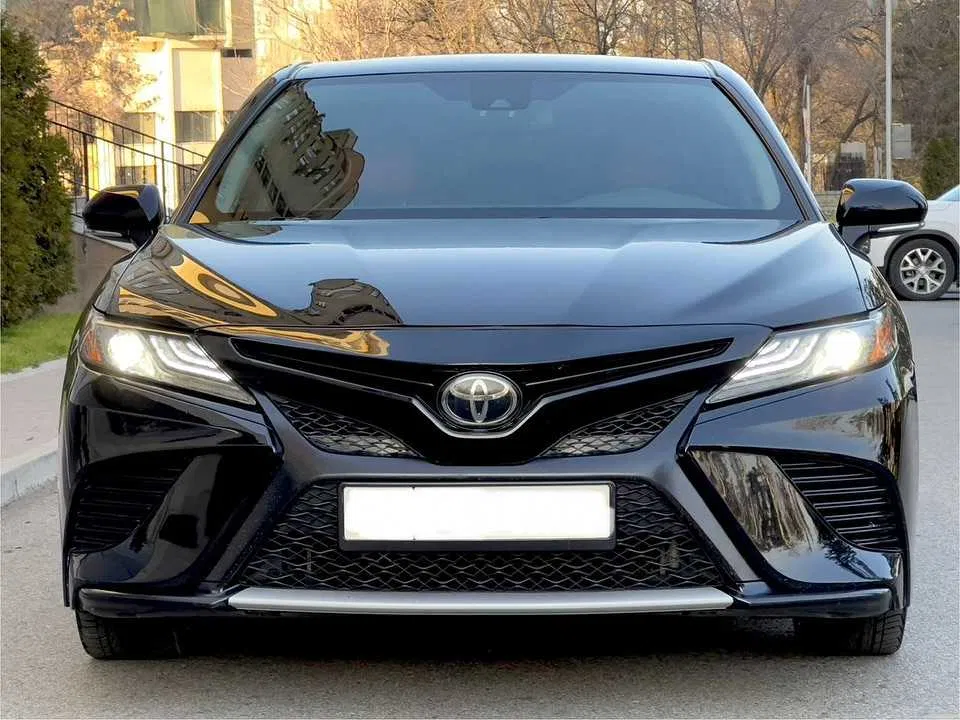 Обслуживание автоматической коробки передач Toyota Camry 3.5 V6. Показан этап замены масла в АКПП: снятый поддон, магниты со следами износа и процесс заливки свежей трансмиссионной жидкости. Используется щадящая технология замены, обеспечивающая стабильную работу коробки и снижение износа узлов.