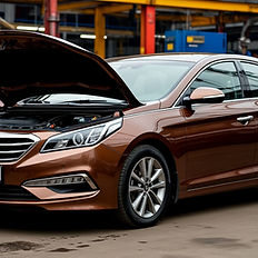 Изображение показывает сервисный процесс на Hyundai Sonata YF в версии с V6-двигателем. Коробка A6LF открыта, мастер проводит чистку поддона и замену расходников. Рядом расположены ёмкости со свежим ATF и оборудование для аппаратной прокачки. Видна чистая и организованная зона сервиса, акцентирующая качество обслуживания.