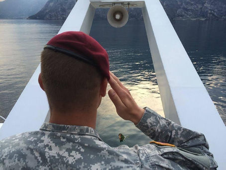 A U.S. paratrooper from Vicenza salutes over the waters where the DUKW sank, as a wreath honors the 25 missing soldiers of the 10th Mountain Division.
