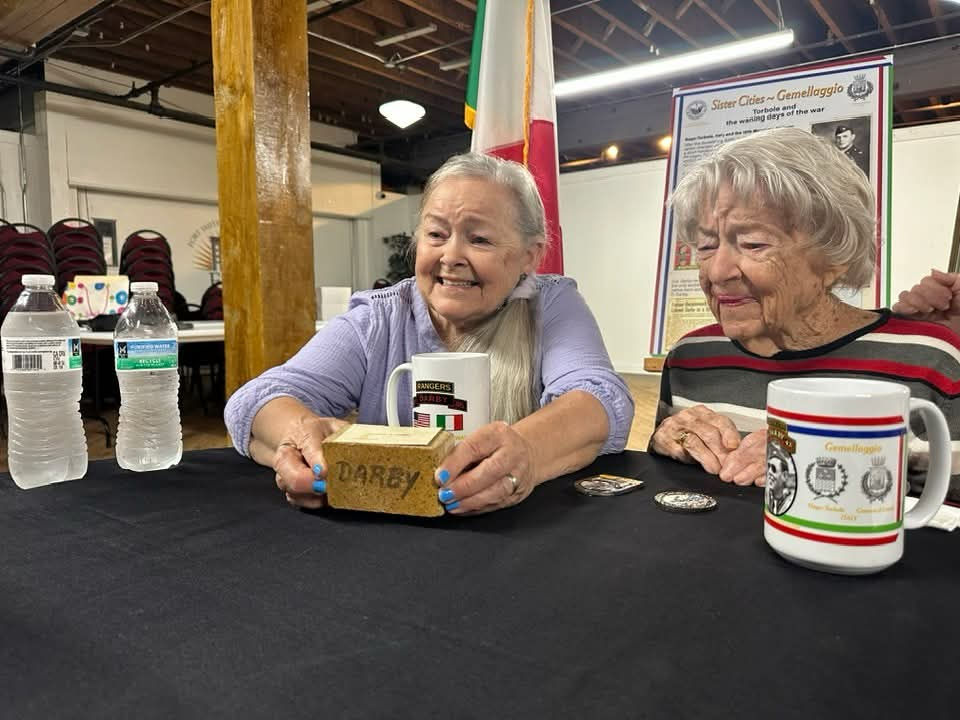 Sally Batten Hailslip showing the film crew an original brick from the original Fort Smith High, the future Darby Jr. High (Darby Middle School).