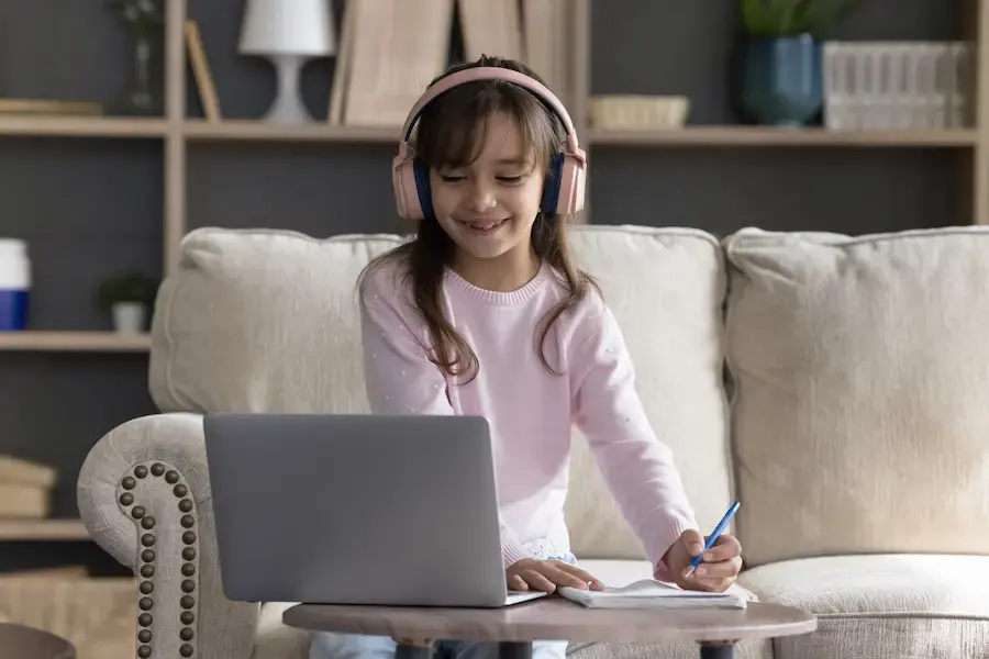 A young girl with dyslexia is in a supportive zoom session with her reading tutor
