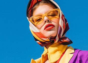 A model in a picture wearing glasses and a scarf on her head.
