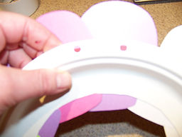 Kidfunideas.com Winter mitten wreath picture of making holes in the back of the wreath form for hanging