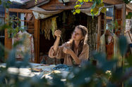 Hands preparing tags for naturally dyed clothing in a studio