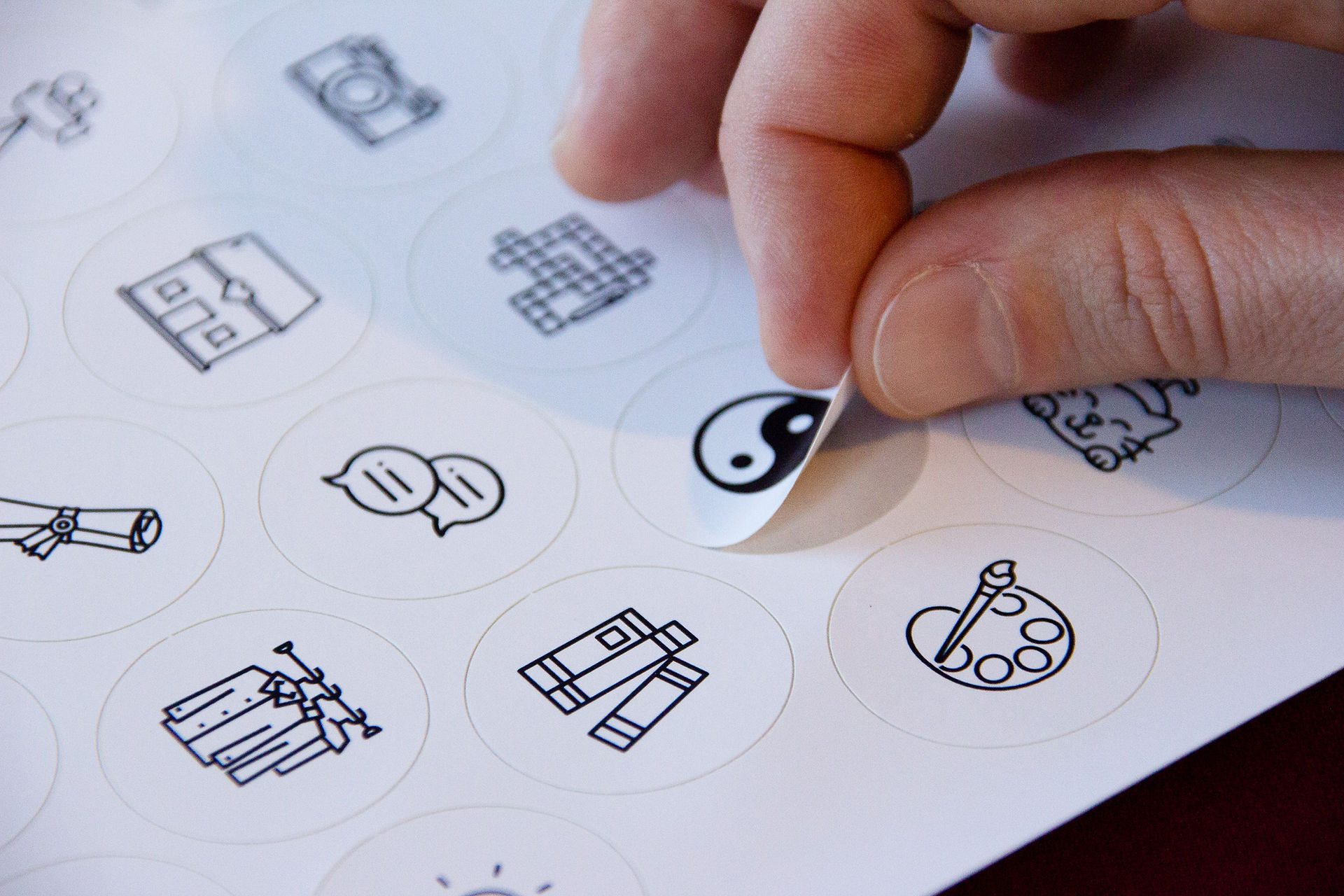 A sticker sheet and a finger grabbing a sticker