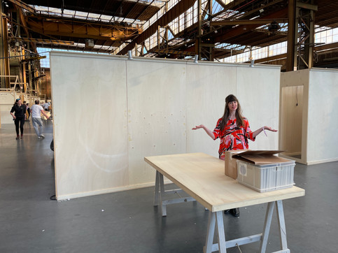 Iris standing in front of an empty wall at event booth