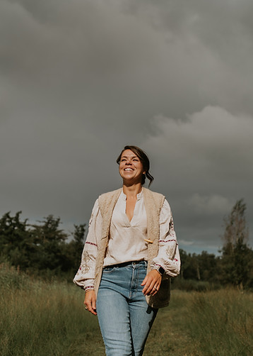 Vrouw loopt in een open veld en kijkt omhoog