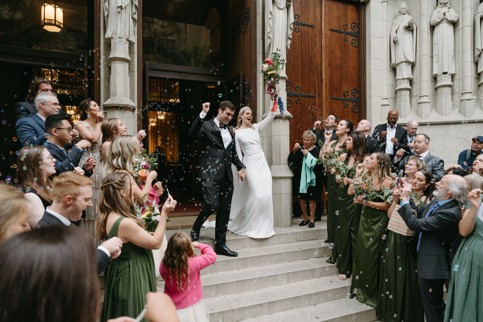 bride and groom coming out of the church and the family is cheering them up 