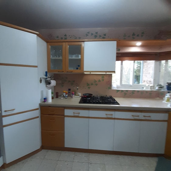 המטבח לפני השיפוץ- חזיתות פורמייקה מיושנות, ארונות עליונים וקרניז עליון שמכבידים את מראה המטבח, מזווה שבנוי באלכסון ומכיל מעט מאוד וקירות צבועים