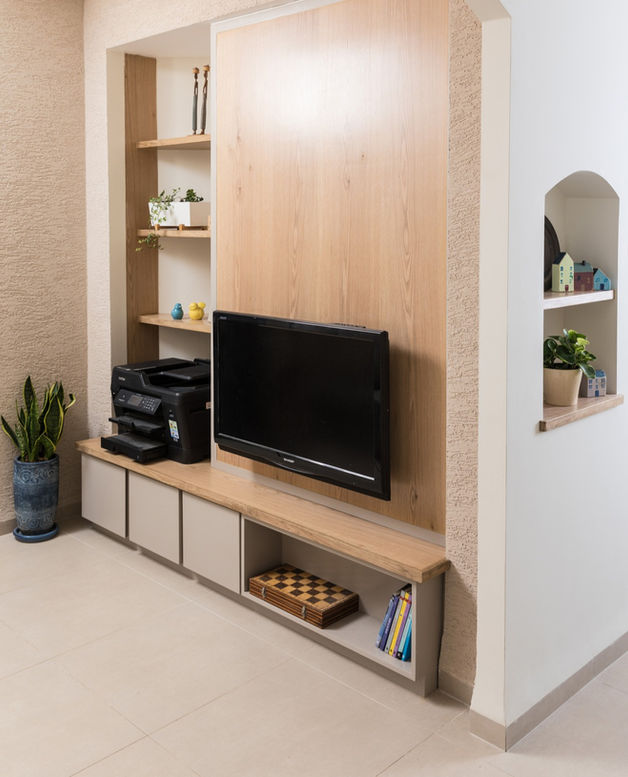 נגרות בפינת משפחה: מזנון גדול סגור ברובו, לוח פורניר אלון עליו תלויה הטלוויזיה ולצידו מדפים גדולים