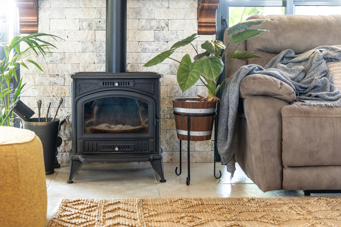 קיר אבן וקמין לצד הספה