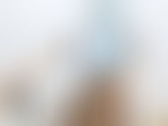 מדרגות מחופות פרקט ומעקה ברזל עם מאחז עץ שעולות לכיוון דלת חצי פתוחה מזכוכית