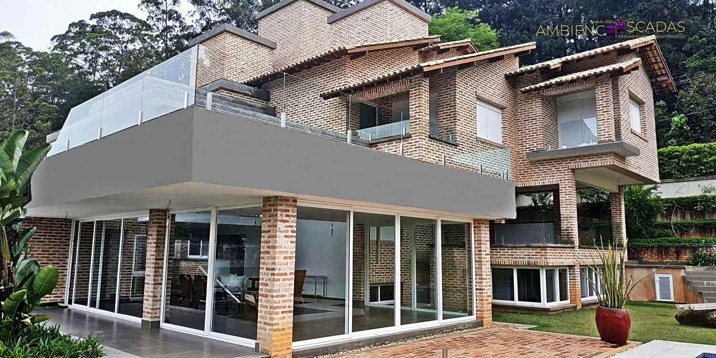 Guarda corpo em vidro fixado em colunas duplas de aço inox. Colunas com fabricação própria, tamanhos a escolher e com maior resistência. Guarda corpo instalado em varanda de residência em Aldeia da Serra em São Paulo.