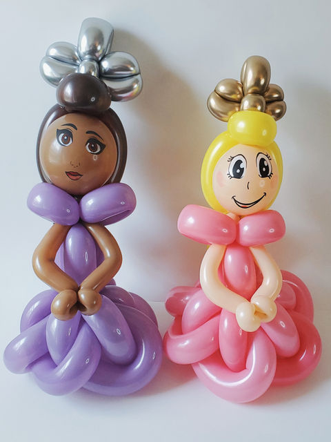 Balloonables 2 Princesses Balloon Animals, one is in a pink dress with a gold tiara and the other is in a purple dress with a silver crown