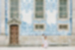 Couple walking in front of old building with Portuguese tiled wall