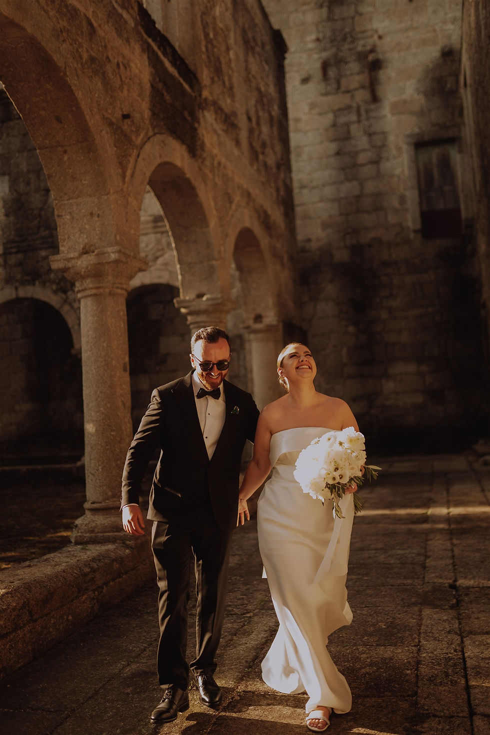 Bride and groom walking in the courtyard of old monastery