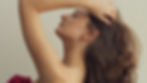 Model moving hand through her hair, showing a delicate thin earring