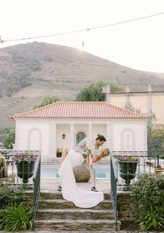Groom kisses bride on top of the stairs