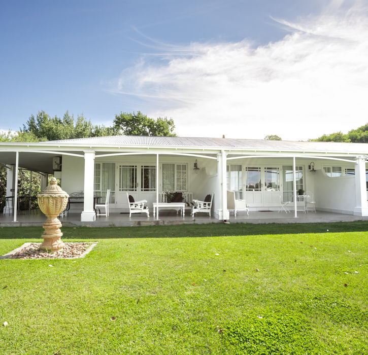 Exterior view of La Riviera Guesthouse with white veranda.