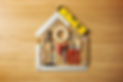 Conceptual house composed of DIY and construction tools on hardwood flooring, top view.jpg