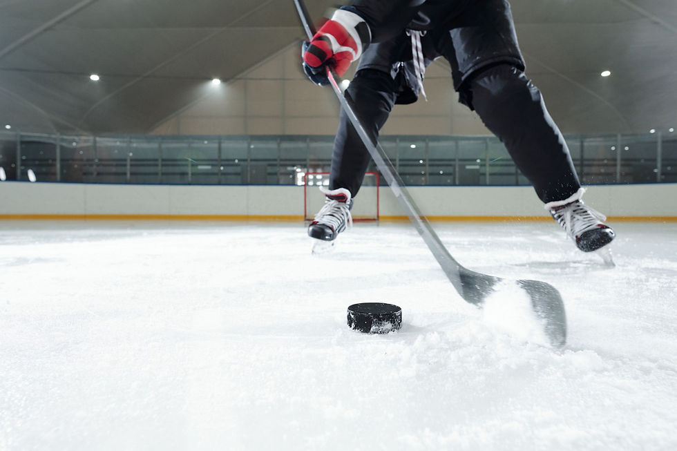 male-hockey-player-sports-uniform-gloves-skates-moving-down-rink-front-camera-against-stad