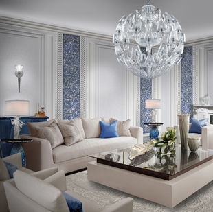 Luxury living room with a white Chinoiserie fireplace, bar area, and white wall panels featuring blue floral wood carvings by Alexander's Collection.