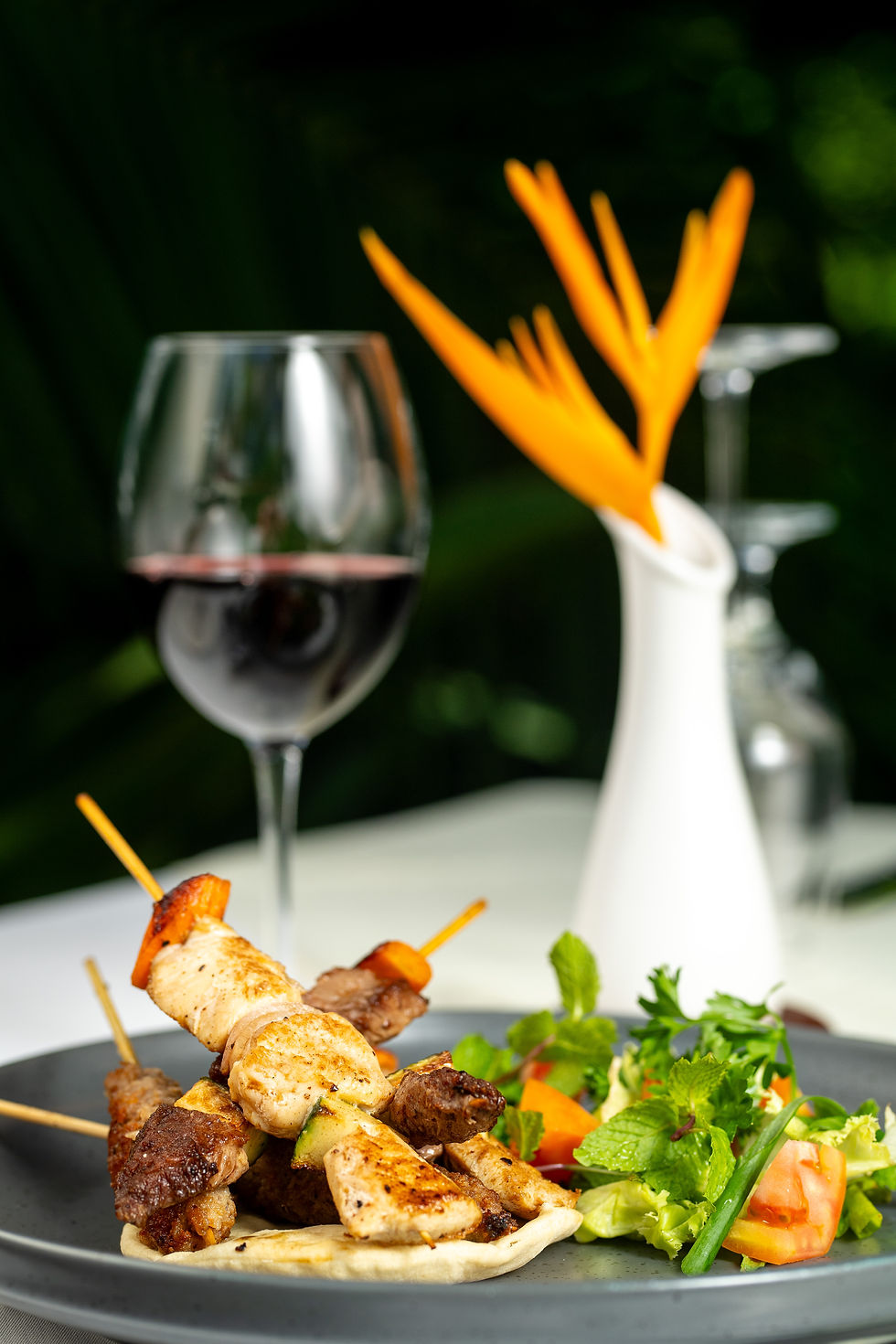 Luxury restaurant dining experience in Zanzibar with grilled skewers, wine and tropical atmosphere photographed by Michal Dzikowski