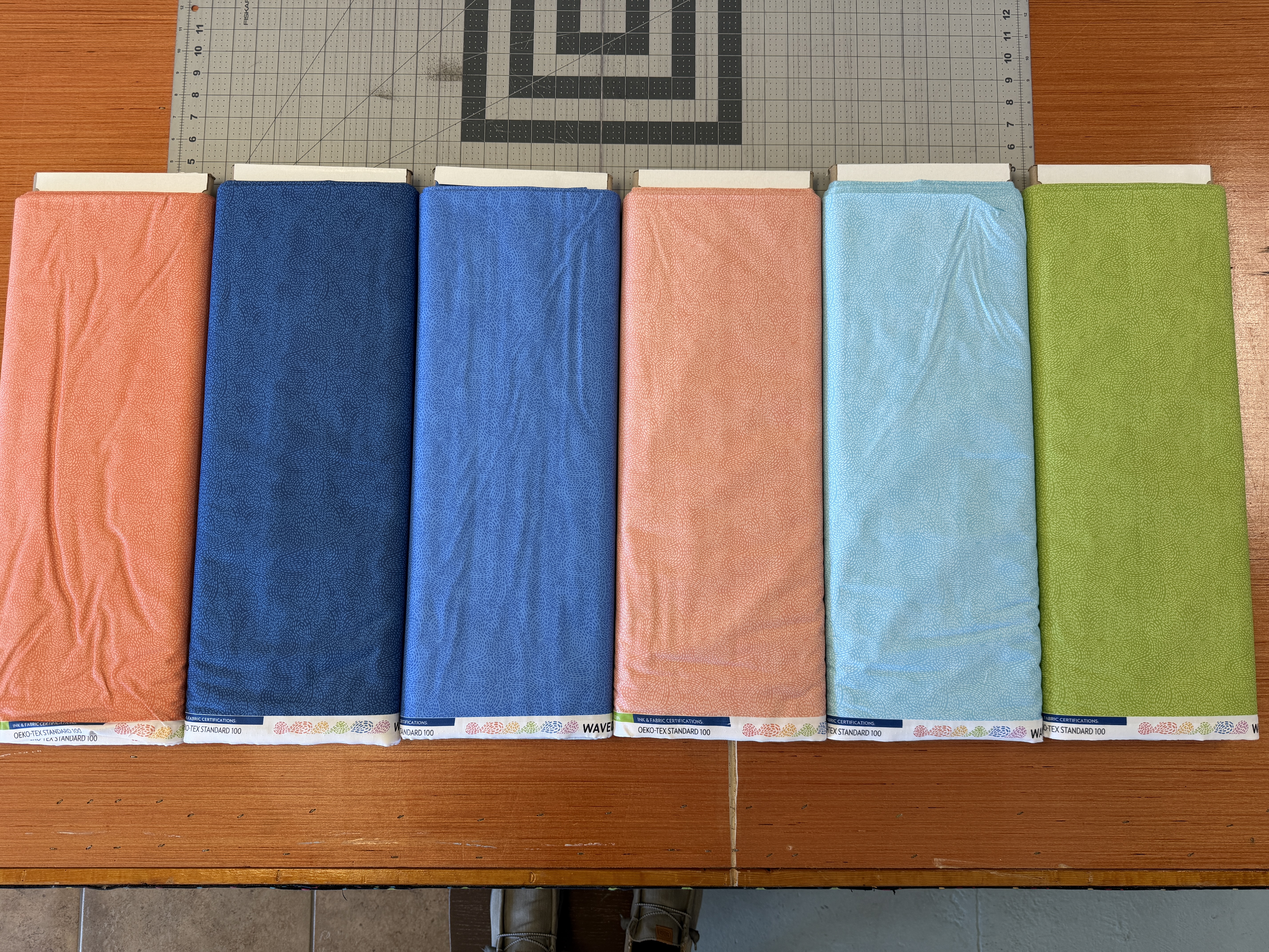 Original photograph of six Waved fabric bolts on the shop cutting table