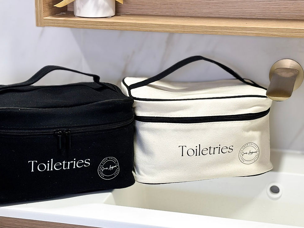 Two toiletry bags on a bathroom counter (one black and one cream)