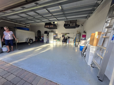 Woman standing in garage with trailer, boxes, and various items inside