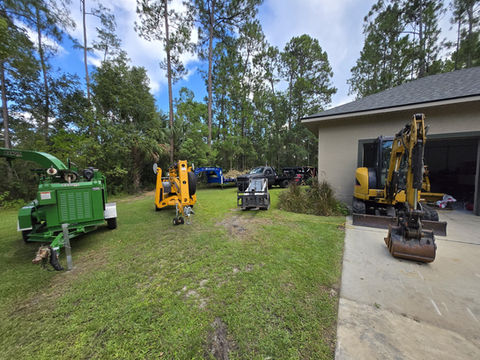 Heavy machinery lined up on grass in preparation for landscaping work.