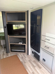 RV interior with TV, electric fireplace, and storage