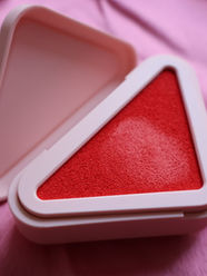 scatola a forma di triangolo rosa con dentro blush colore rosso prada