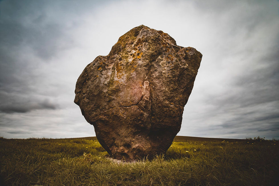 large boulder, illumined in a field