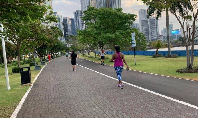 People exercising on a paved path in an urban park