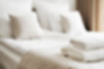 Selective focus on white fresh towels in hotel bed. Room service concept. Closeup white on