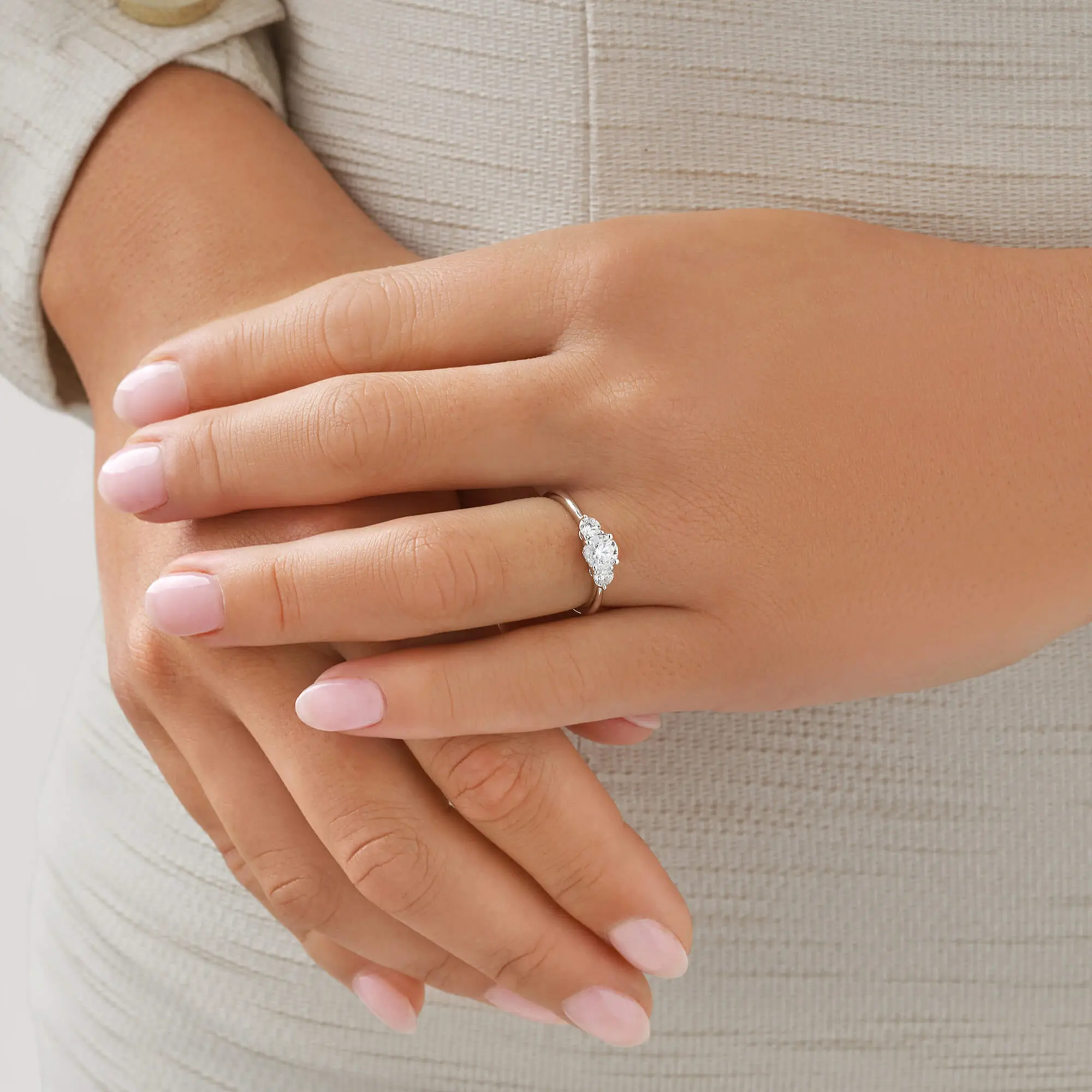 Anillos tresillo con diamante oro blanco en mano de mujer