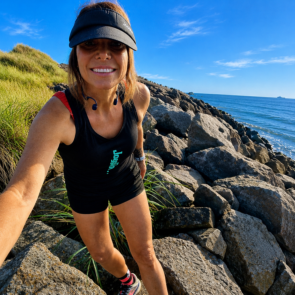 Thumbnail: Woman in a black race vest running on a rocky shoreline.