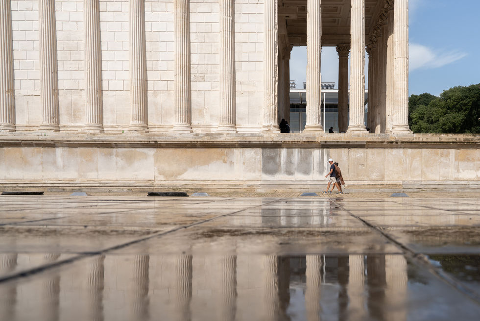 Maison carree nimes reflected on wet marble floor