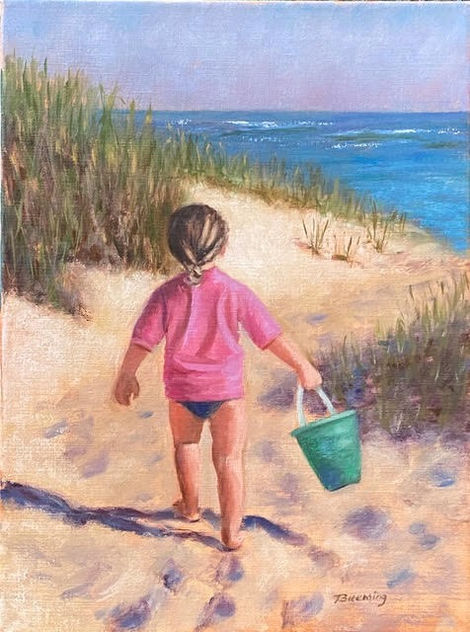 Toddler walks beach carrying pail