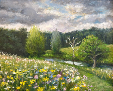 Vibrant wildflowers and trees under a cloudy sky