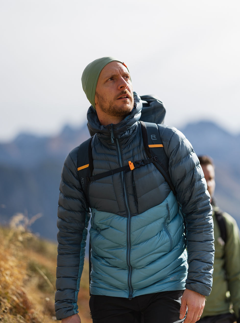 Daniel Meixner im Hero-Shot, führt eine Gruppe, fokussiert in die Ferne blickend – Führung, Alpen Coaching und Orientierung.