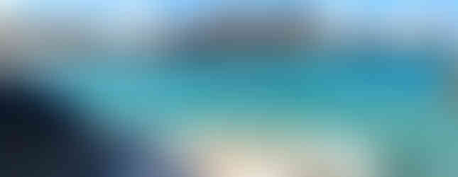 Virgin Gorda exotic beach with huge boulders and turquoise water and people swimming