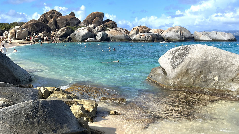 Virgin Gorda beach with huge boulders and turquoise water and people swimming