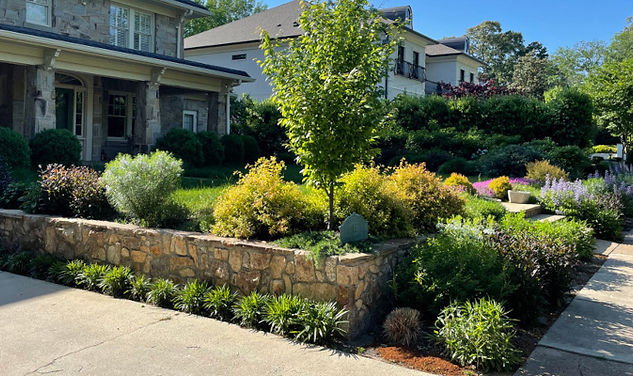 Retaining wall and professionally landscaped front yard in Travelers Rest, SC with native plants, mulch, and enhanced curb ap
