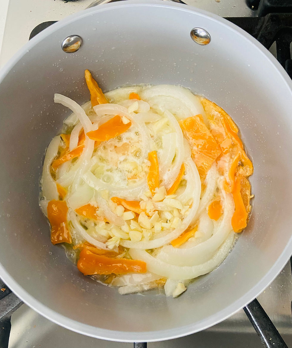 Sautéed Onion, Garlic and Habanero in a grey sauce pan on a stovetop