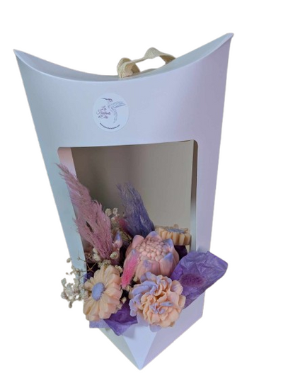 Composition parfumée pour la Saint-Valentin dans une boîte blanche élégante, ornée de fleurs parfumées pastel, de pampas colorées et de gypsophile, créant une ambiance délicate et romantique.