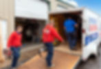 Patriot Heat & Air team loading equipment into a service trailer outside the shop, preparing for the workday.