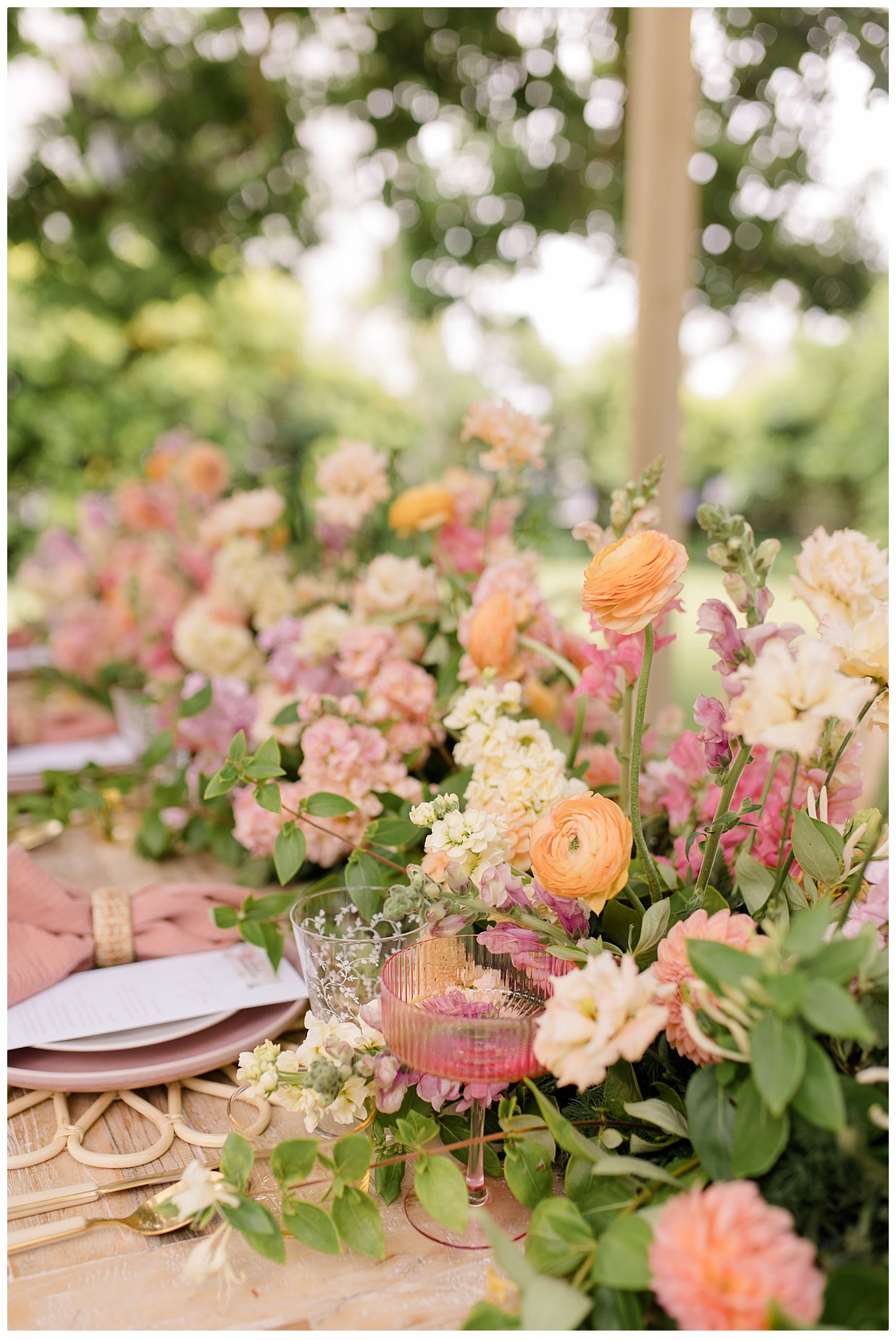 Pinks, Peach florals and greenery. table setting at a wedding.