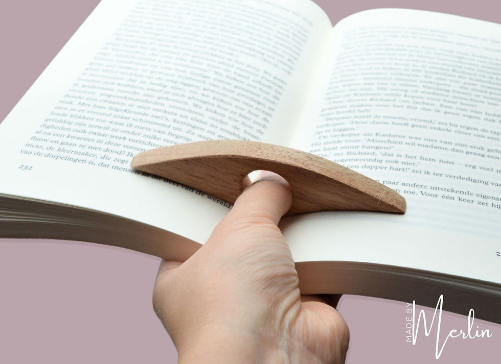 Duimboekenhouder in gebruik – duim door gat, hand ondersteunt opengeslagen boek van onderen, roze achtergrond